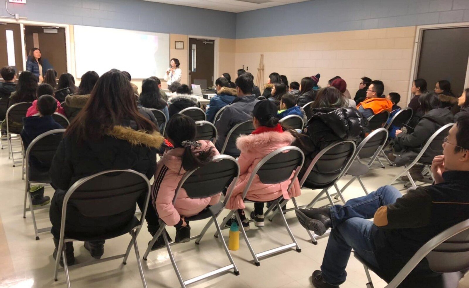 Families and community members attending an educational talk